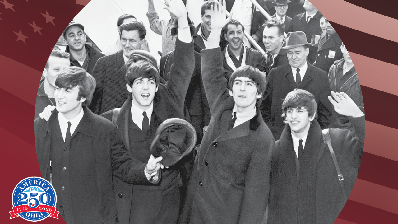 Historic black and white photo of the beatles greeting fans