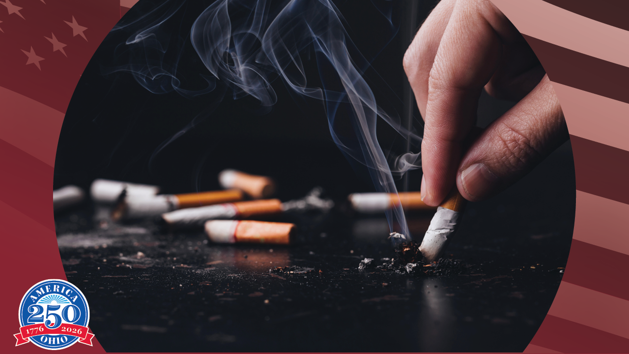 a hand putting out a cigarette on a countertop