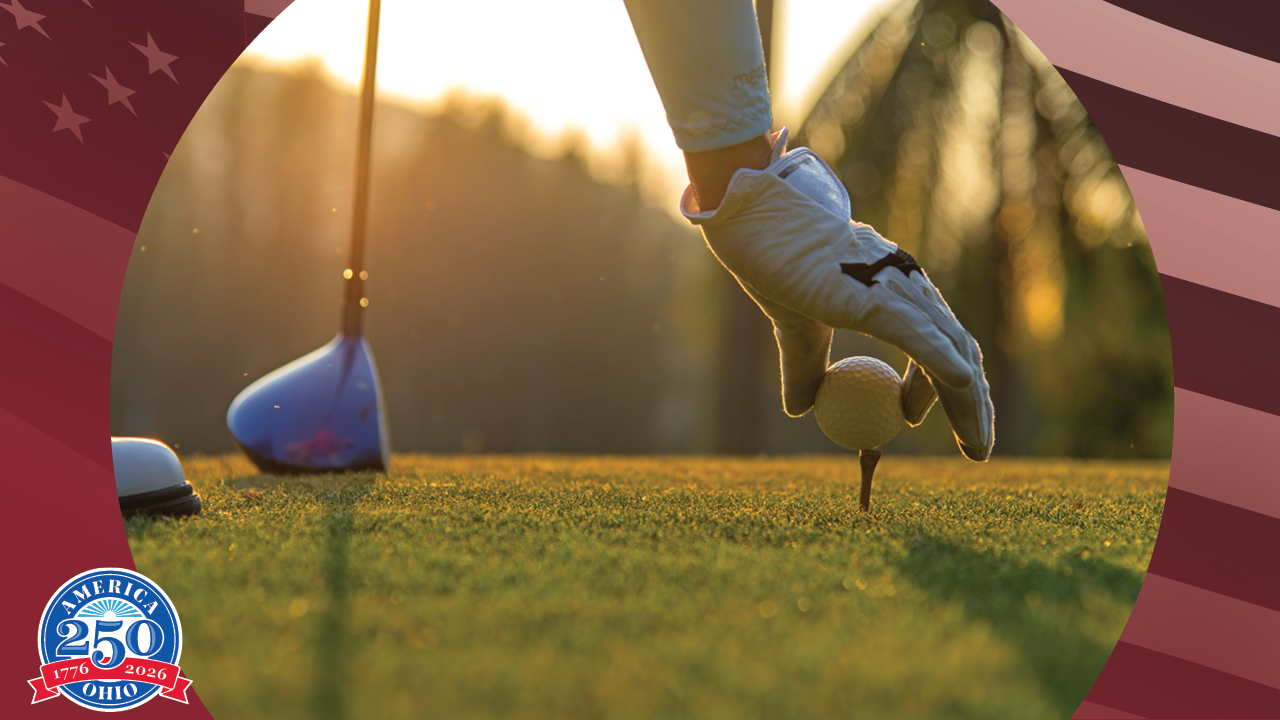 a golfer placing a golf ball on a tee