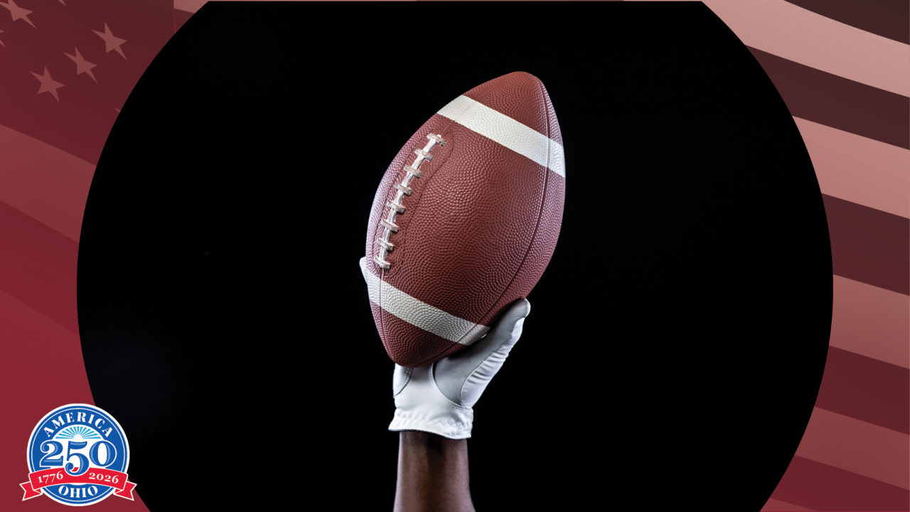 A hand holding an American football