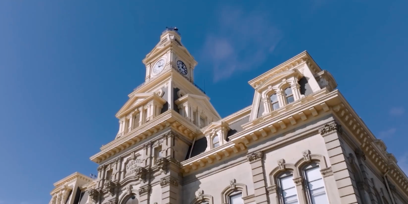 Upwards angle of the Muskingum County Courthouse, which features a clock tower.