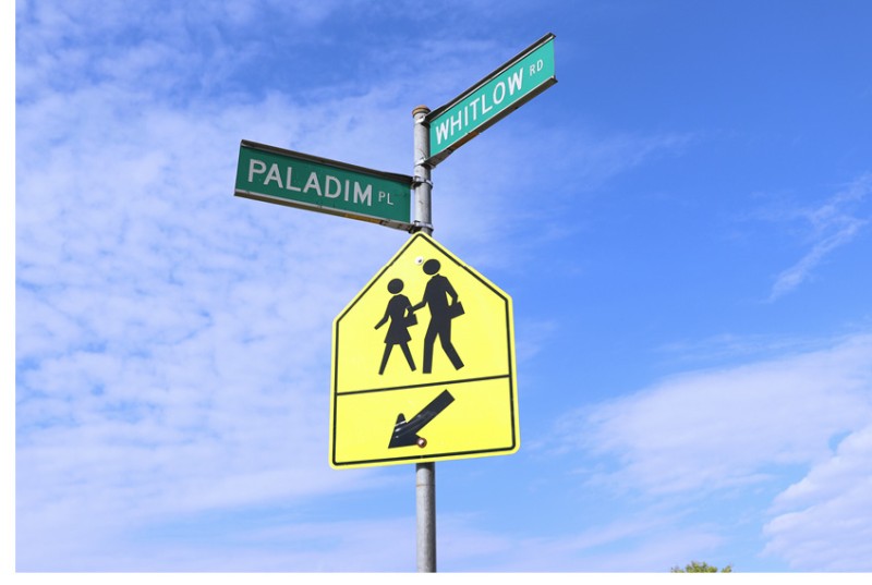 Image of a yellow pedestrian crosswalk sign below green street signs for Paladim Place and Whitlow Road.
